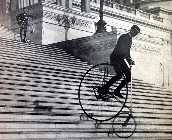 Men riding bicycles down stairs