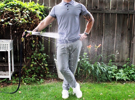 man spraying himself with hose