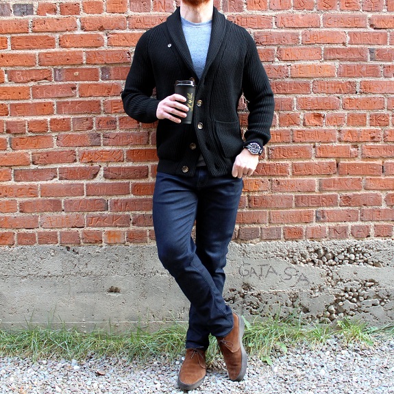 Man in front of brick wall with coffee